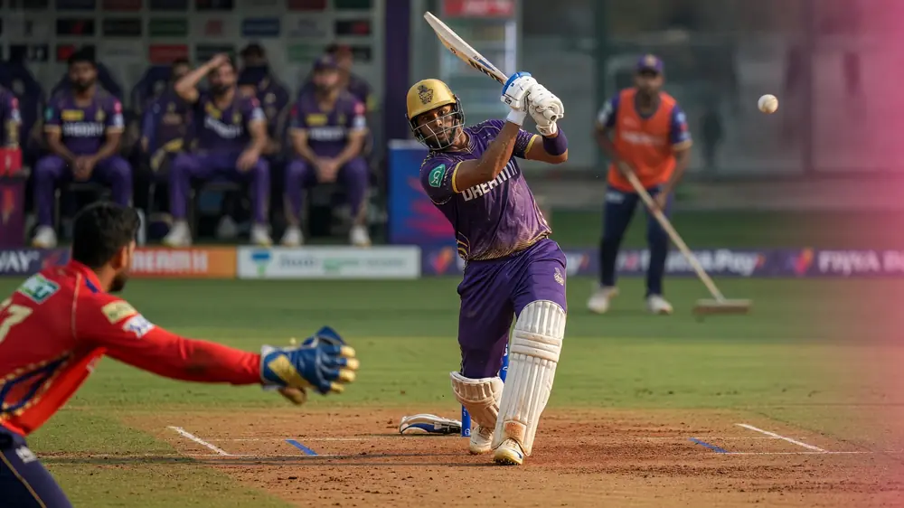 Close sideline action of a batter driving through the off side during a night white-ball innings under stadium lights